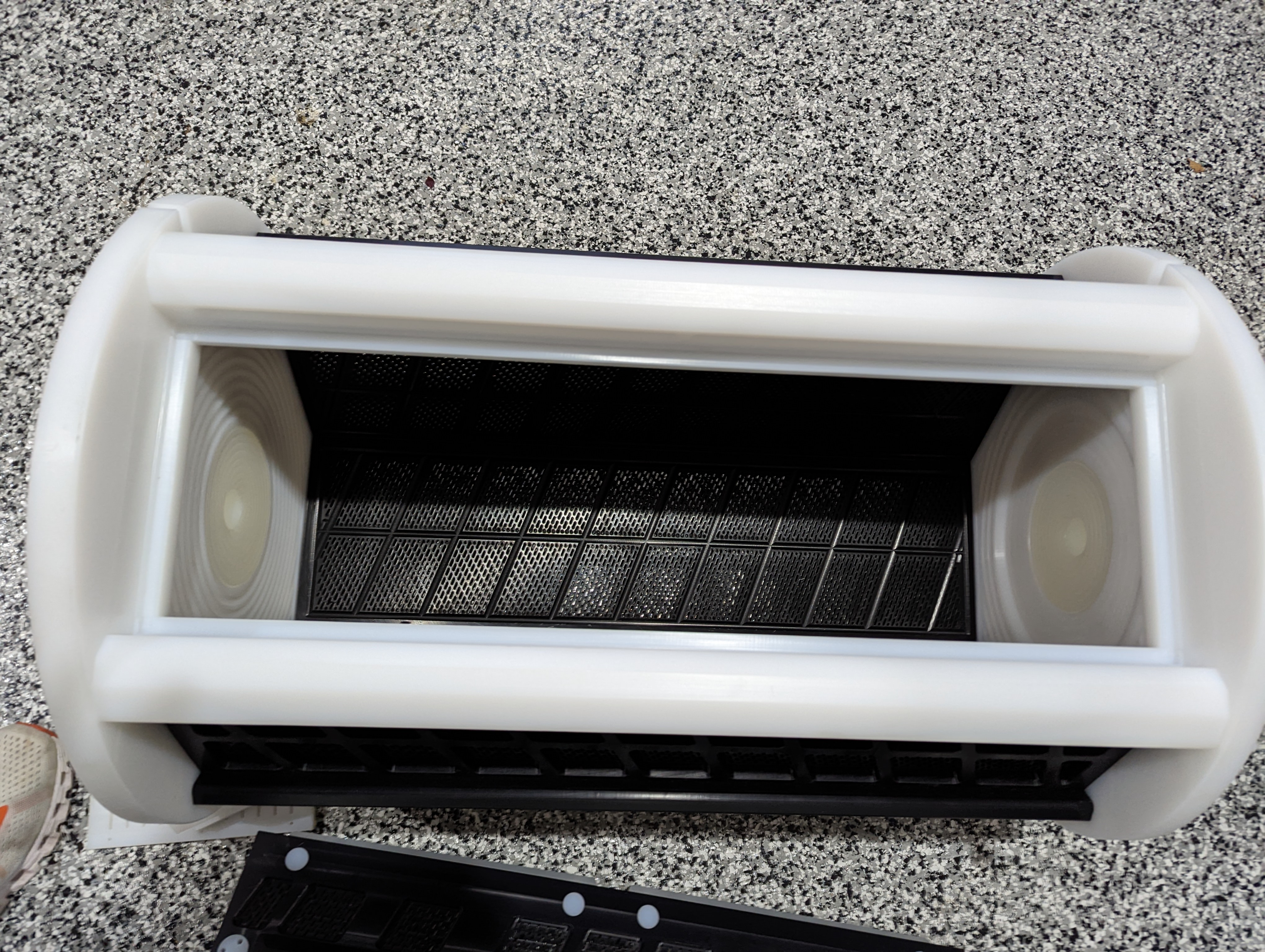 Inside an Eagle Engineering PE1000 plating barrel — machine-cut perforations and work breaker bars